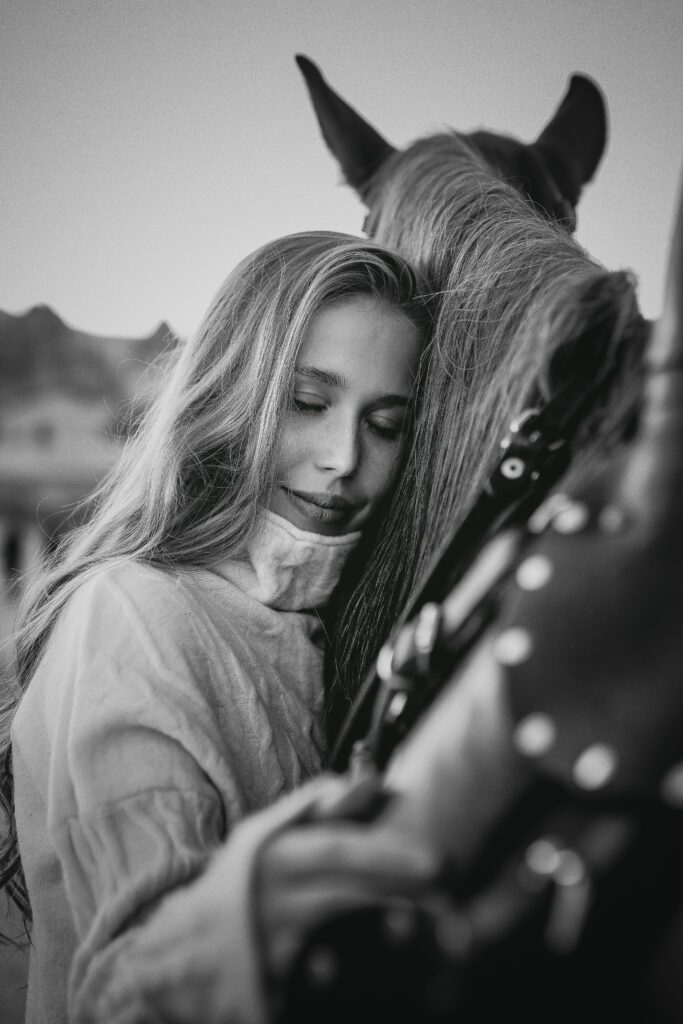 A young woman feeling a deep connection with her horse – a divine feminine power 
